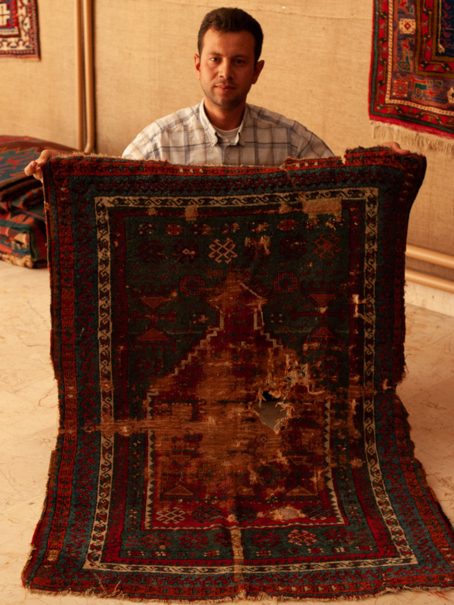 A precious antique carpet before repair by our experts