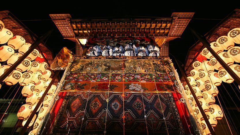 Gion Matsuri float at night with lanterns and textiles